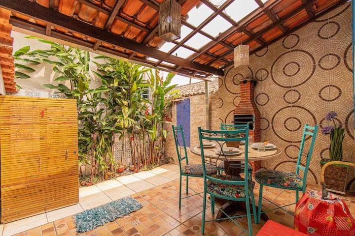 a patio with a table and chairs in a room at Chalés Ilhabela in Ilhabela