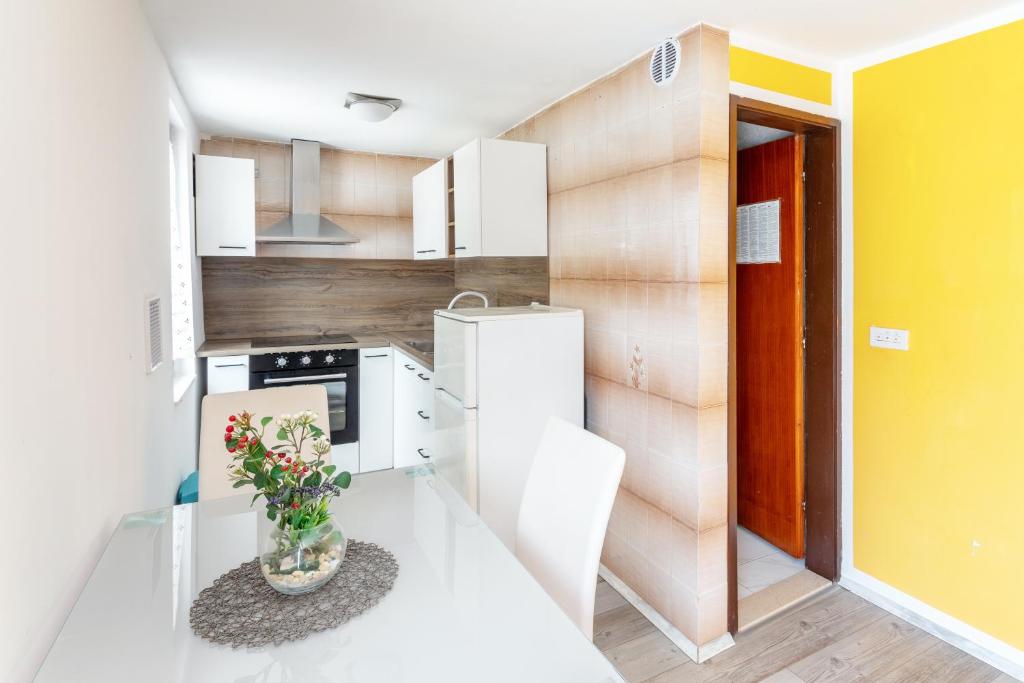a kitchen with a table with a vase of flowers on it at Villa M&M - ZF Hvar in Hvar