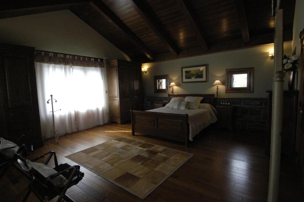 a bedroom with a bed and a large window at Hotel Rural El Portón de Murillo in Broto