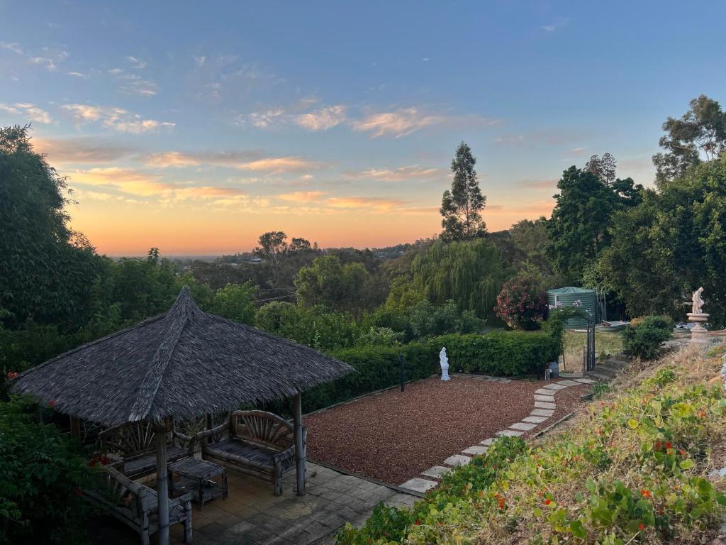 a garden with a bench and an umbrella at Bright & Beautiful Home On The Hills! in Kelmscott