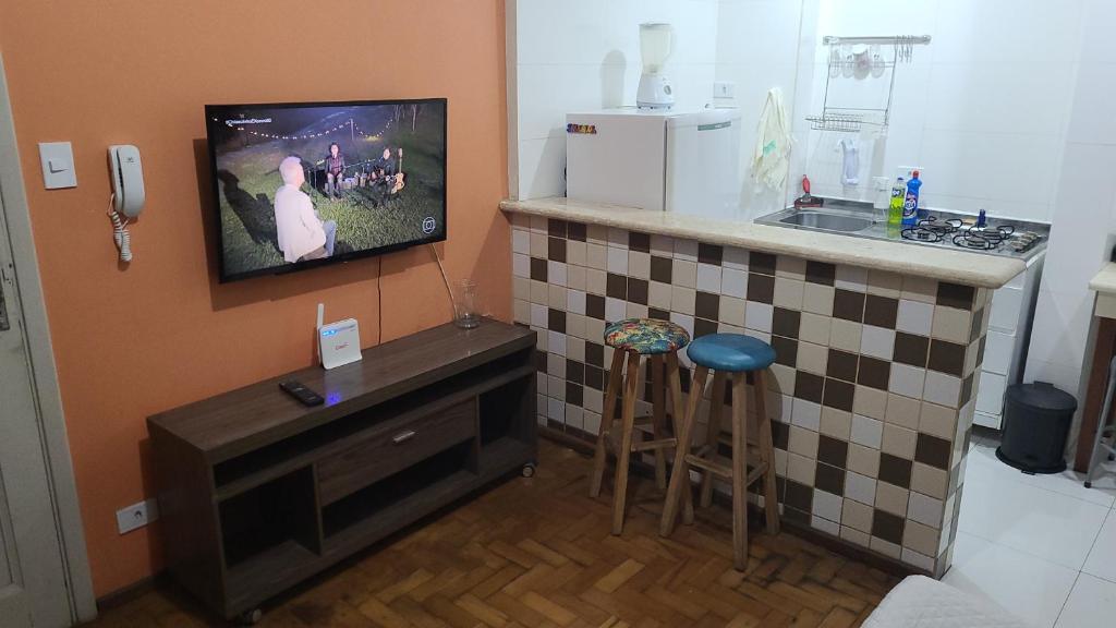 uma cozinha com um balcão e uma televisão na parede em Apartamento Tubal em Uberlândia