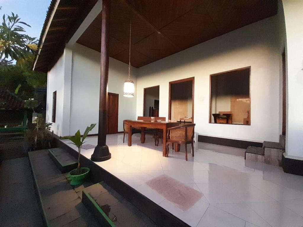 une terrasse avec une table en bois dans une maison dans l'établissement Sasak Lebung Home, à Senggigi