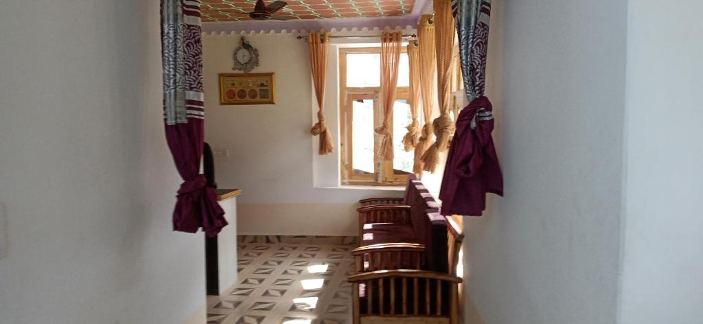 einen Flur mit einer Gruppe von Stühlen und einem Fenster in der Unterkunft Sukoon Turtuk Home Stay in Turtok
