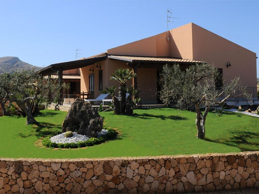 un bâtiment avec un jardin en face d'un bâtiment dans l'établissement Holiday Home Nicola Santoro, à Custonaci