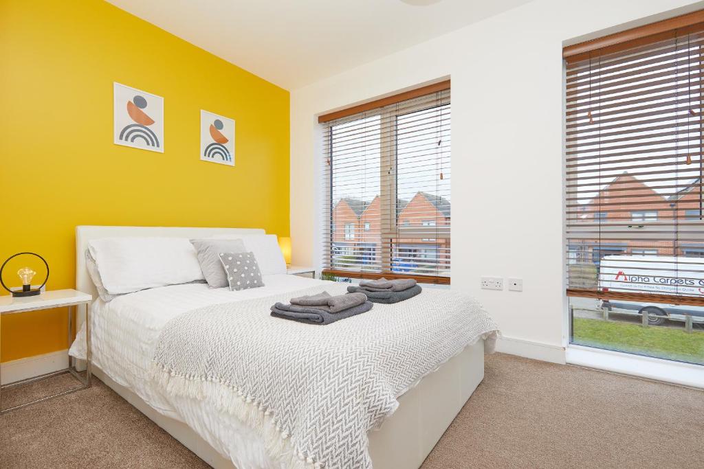 a bedroom with yellow walls and a bed and a window at Royal Derby Hospital House (2.5 bath) in Derby