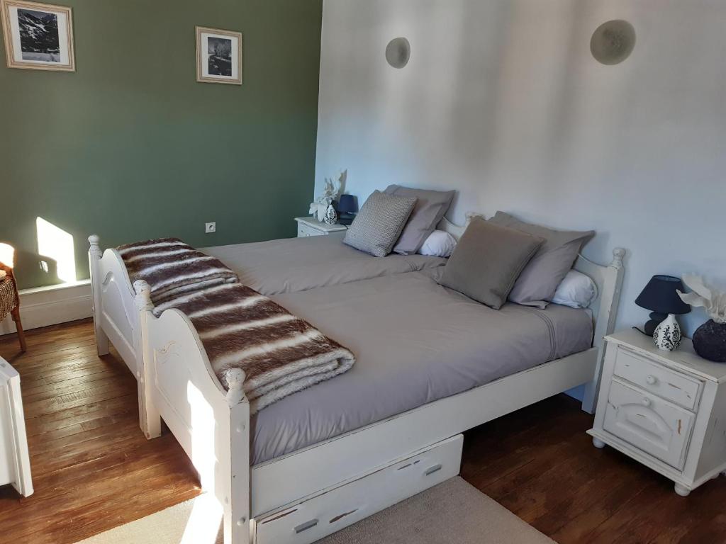 ein weißes Bett mit einer Decke in einem Schlafzimmer in der Unterkunft Bed and Breakfast Les Airelles in Val-des-Prés