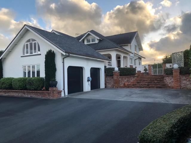 a white house with a driveway in front of it at Grand On Victoria in Hawera