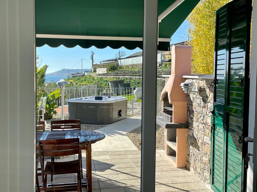 een patio met een tafel en uitzicht op een hot tub bij villetta Sole Mare in Santo Stefano al Mare