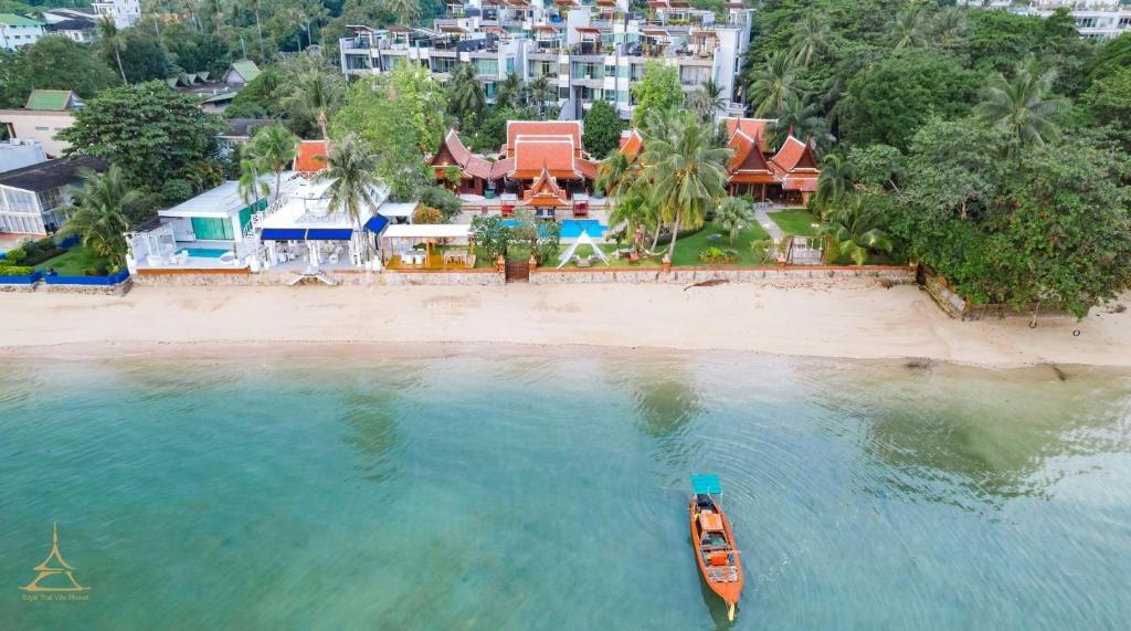 Royal Thai Villa Phuket - SHA Extra Plus في شاطئ راوايْ: اطلالة جوية على شاطئ مع قارب في الماء