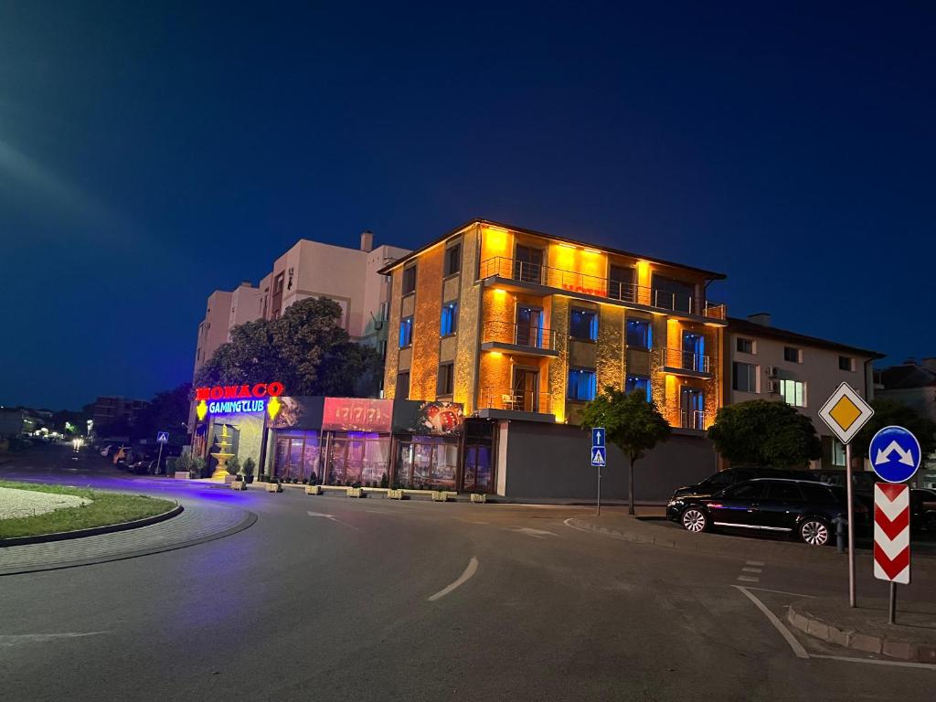 un edificio con luces amarillas en el lateral de una calle en Complex MONACO HOTEL & CASINO en Svilengrad