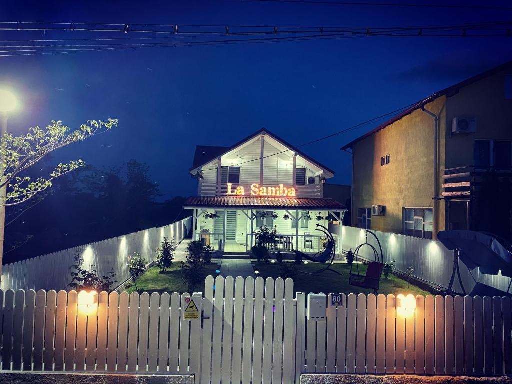 a white fence in front of a house at night at La Samba in Crisan