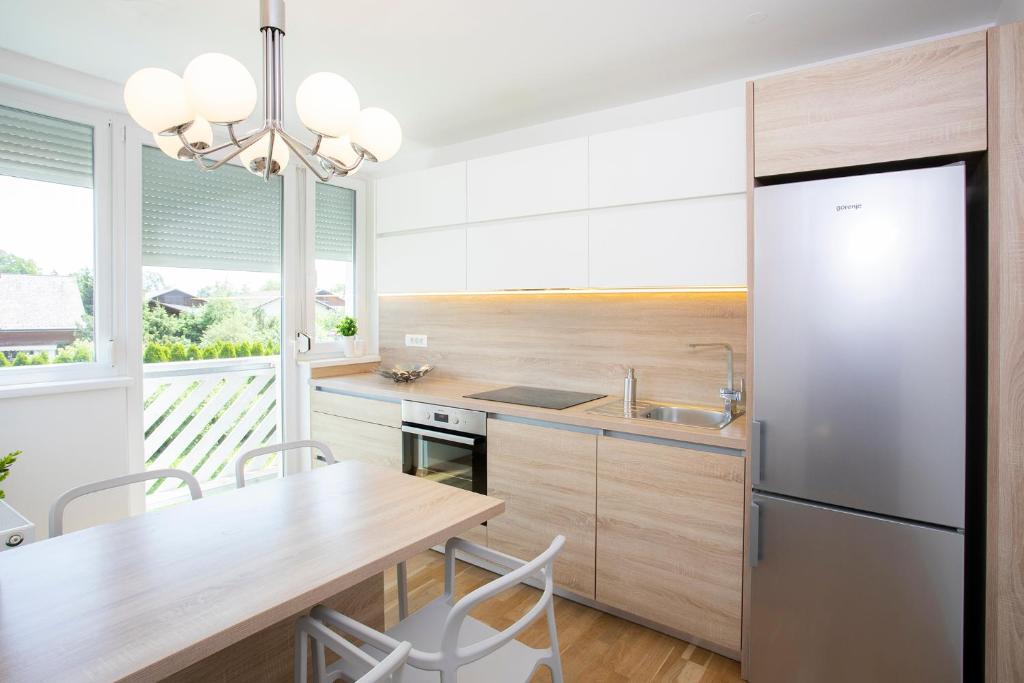 eine Küche mit einem Holztisch und einem Kühlschrank in der Unterkunft Apartments Agenija Bled in Bled