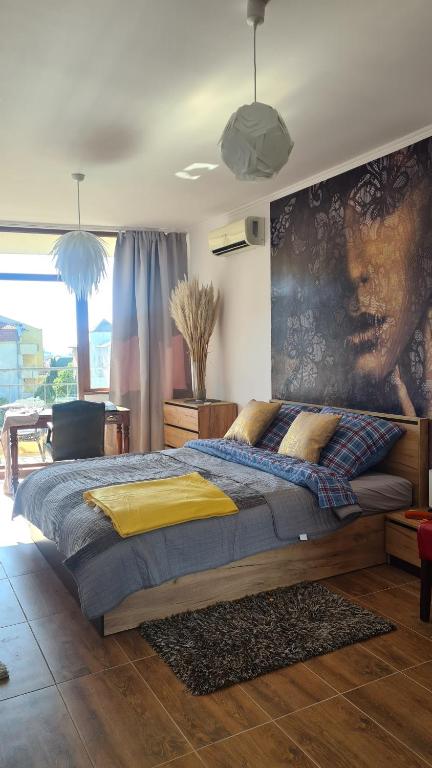 a bedroom with a large bed with a painting on the wall at Sun Wave Apartment Presige in Sveti Vlas
