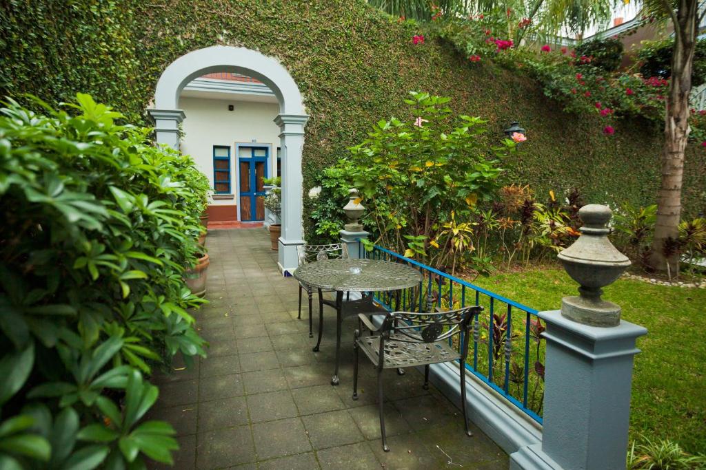 eine Terrasse mit einem Tisch und Stühlen neben einem Zaun in der Unterkunft Posada del Cafeto in Xalapa