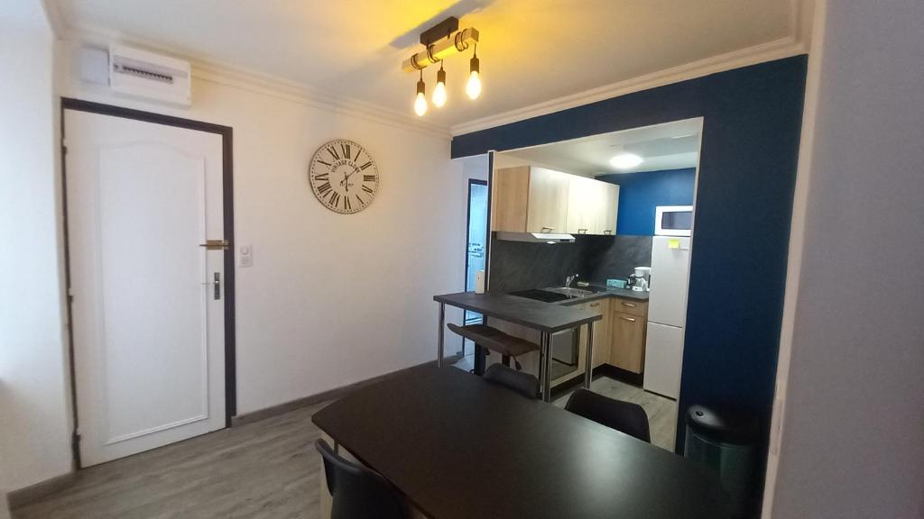 a kitchen with a table and a dining room at Saint-flour appartement au cœur de la ville in Saint-Flour