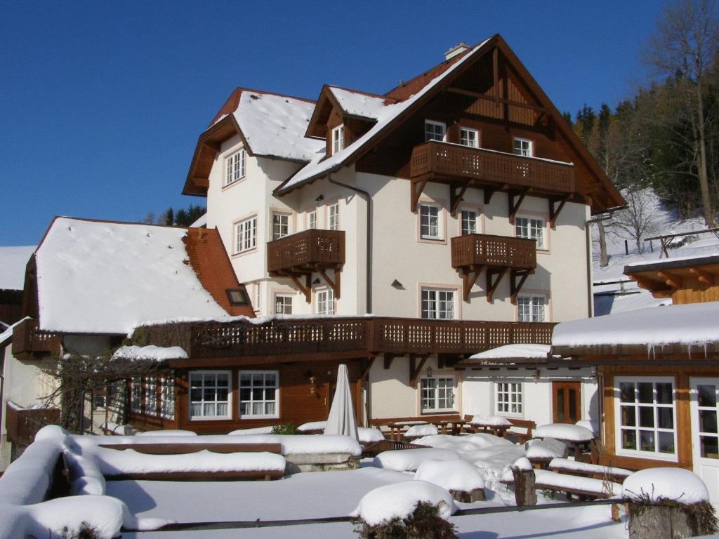 een groot huis met sneeuw op de grond bij Althammerhof in Klamm