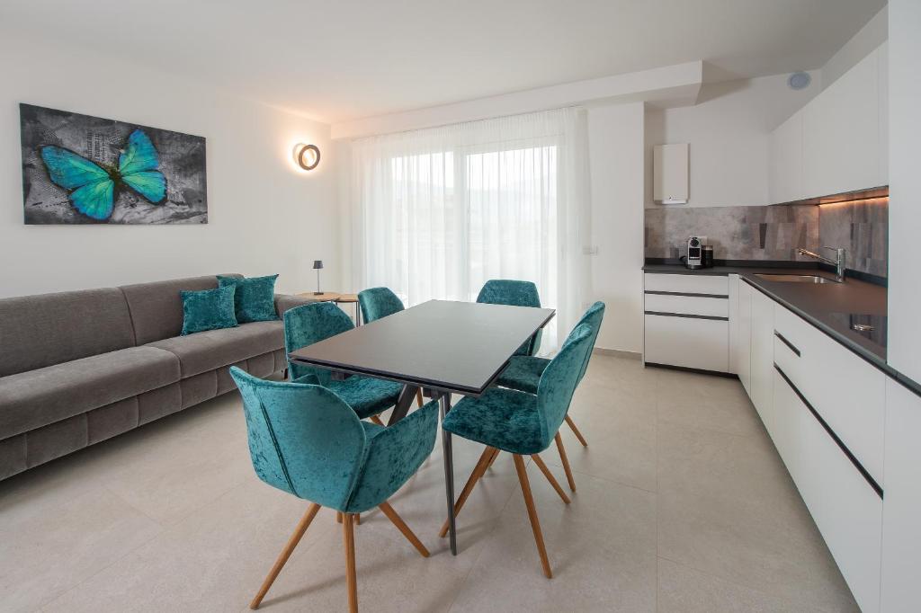 kuchnia i salon ze stołem i krzesłami w obiekcie Suite Butterfly - dolce vita at lake garda w mieście Riva del Garda