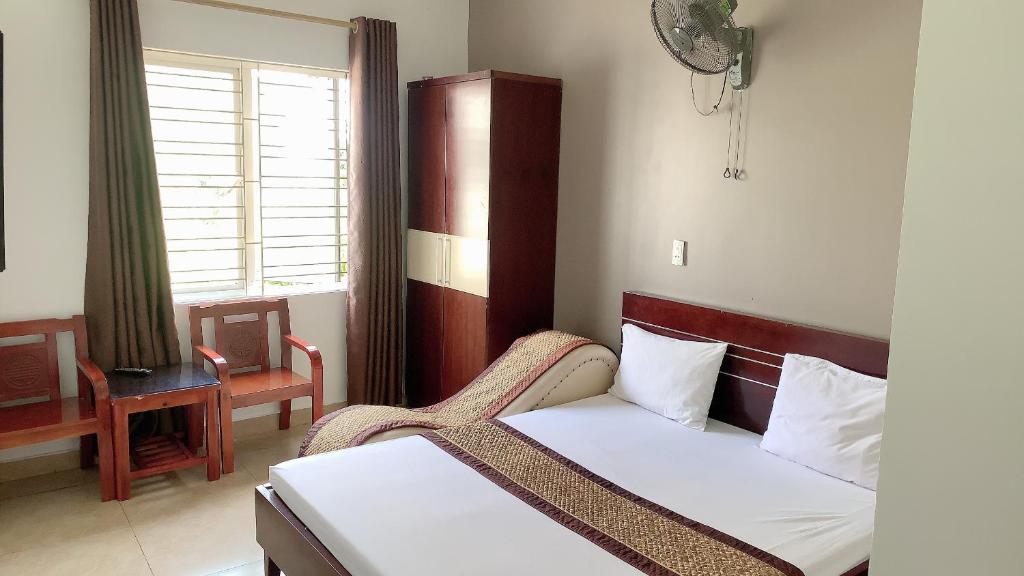 Motel TÂY HỒ في هاي فونج: غرفة نوم بسرير وكرسي ونافذة