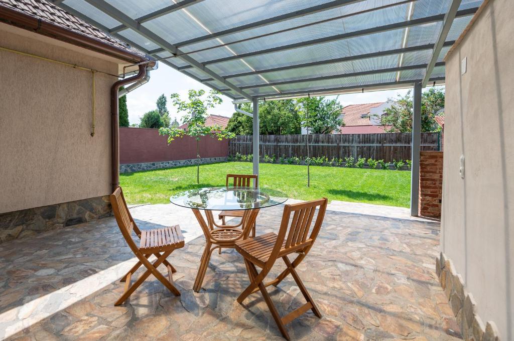 a patio with a glass table and two chairs at Salca Home in Oradea