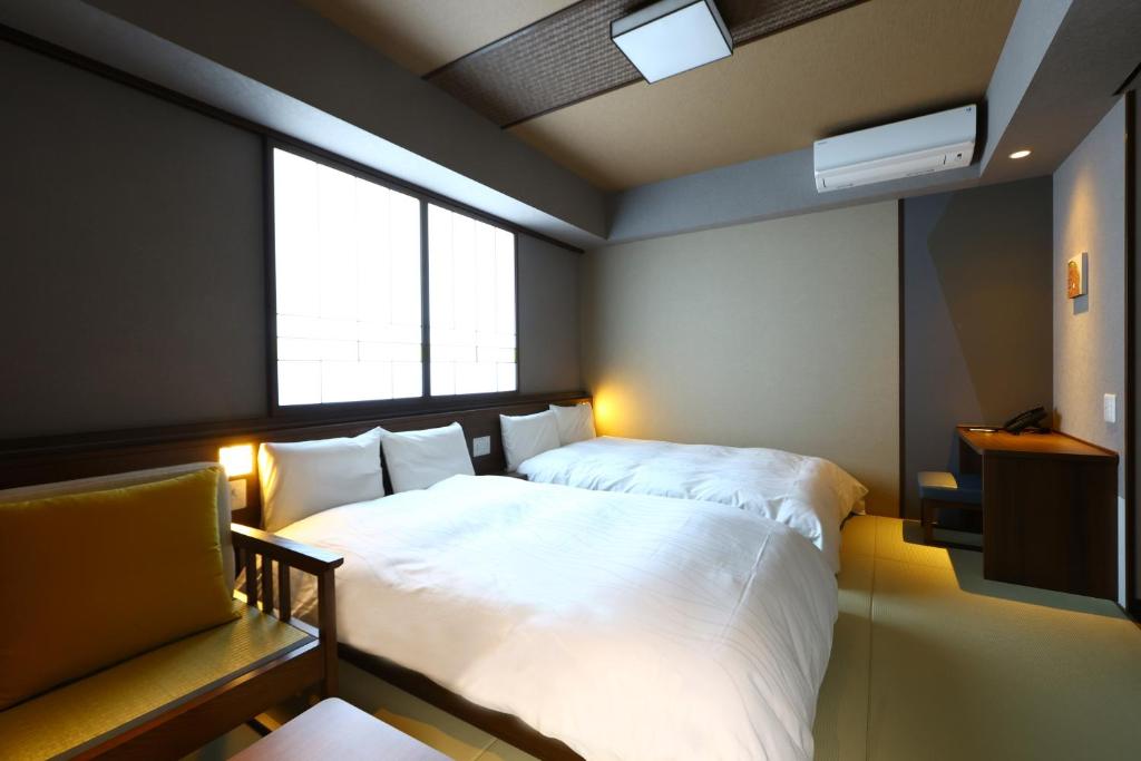 ein Schlafzimmer mit großem Bett und Fenster in der Unterkunft Onyado Nono Matsumoto Natural Hot Spring in Matsumoto