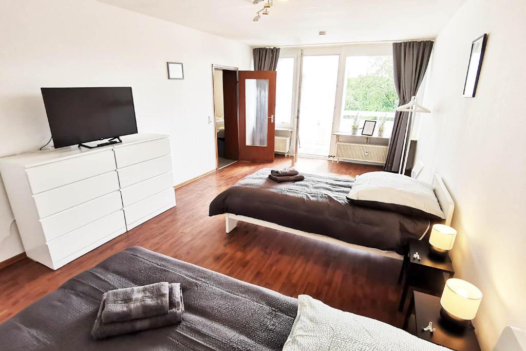 sypialnia z 2 łóżkami i telewizorem z płaskim ekranem w obiekcie Nice apartment in Heusenstamm near Frankfurt w mieście Heusenstamm