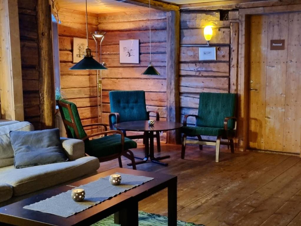 een woonkamer met een bank, stoelen en een tafel bij Renfjällsgården in Edsåsdalen