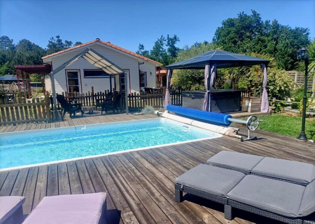 a swimming pool with a gazebo next to a house at Modern house with Pool & Jacuzzi in Carcans in Carcans