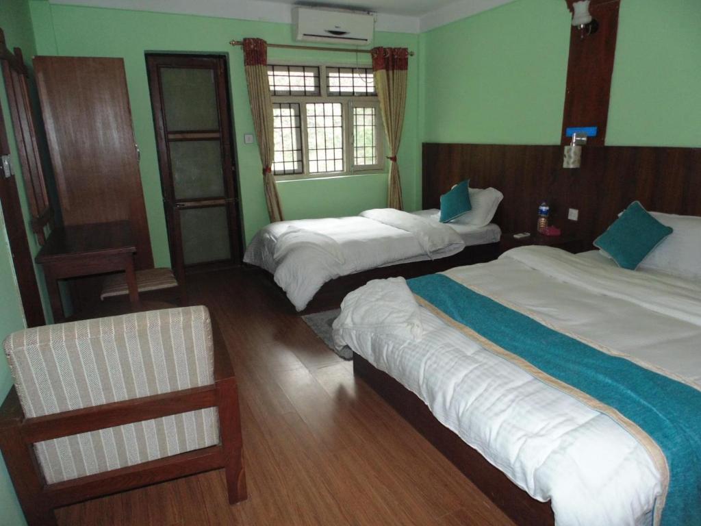 a hotel room with two beds and a chair at River Fun Beach Resort in Gorkhā