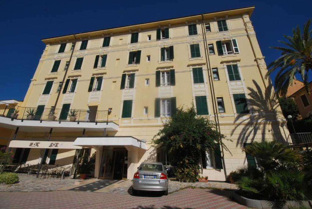 a building with a car parked in front of it at Hotel Esperia in Spotorno