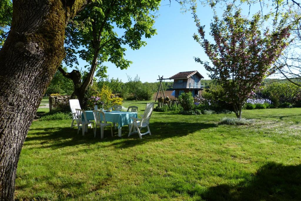 einen Tisch und Stühle in einem Hof mit einem Haus in der Unterkunft L'Echappée Belle Périgord in Cercles
