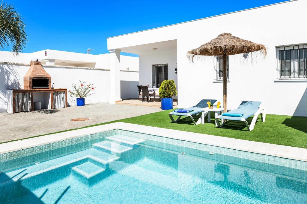 una villa con piscina y una casa en Casa Orilla Sur A, en El Palmar