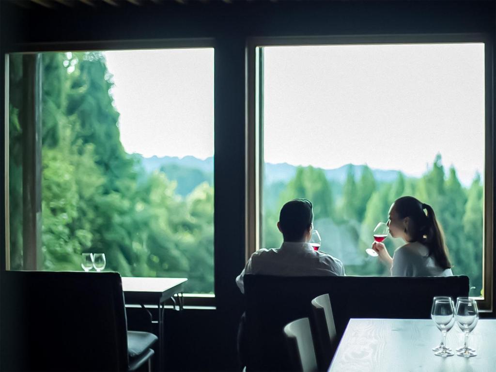 a man and a woman sitting at a table drinking wine at 醸す森 "kamosu mori" in Tokamachi
