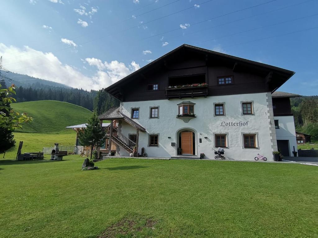 a large white building with a black roof at Ferienwohnung Lotterhof in Heinfels