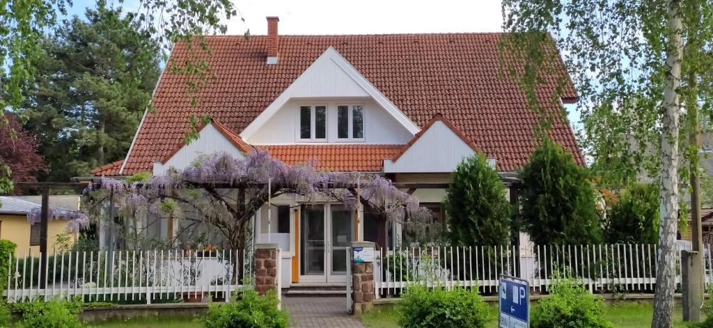 a white house with a white fence and trees at Erika Villa in Siófok