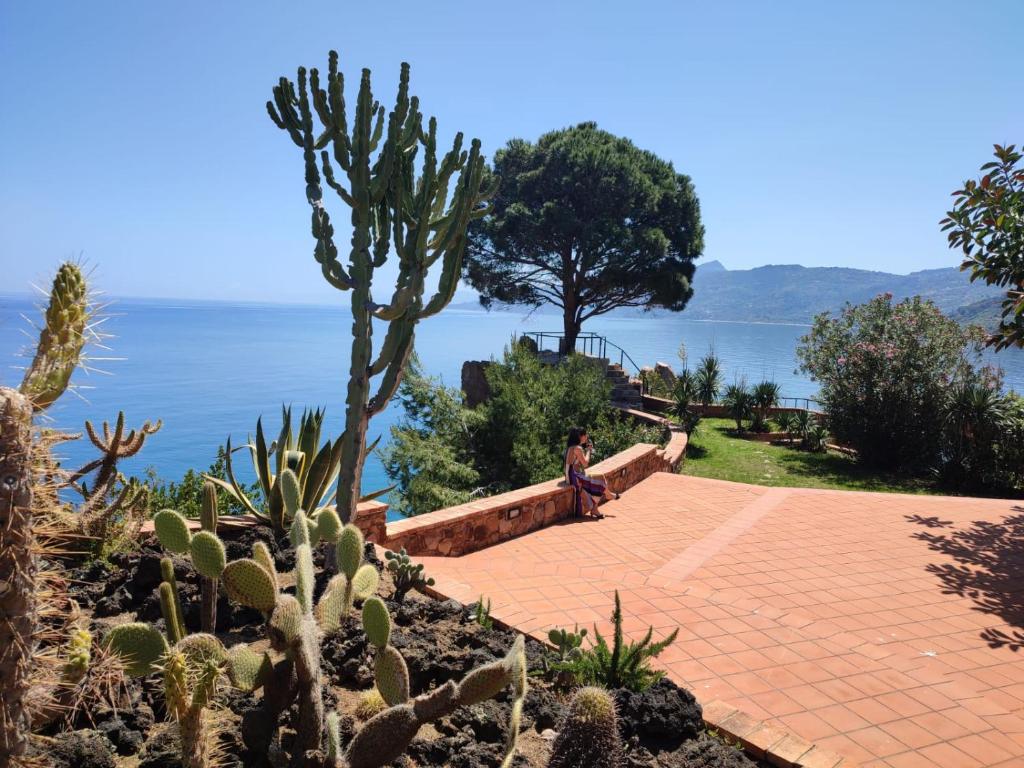 een persoon die op een pad naast een cactus staat bij Kalura Sea House in Cefalù