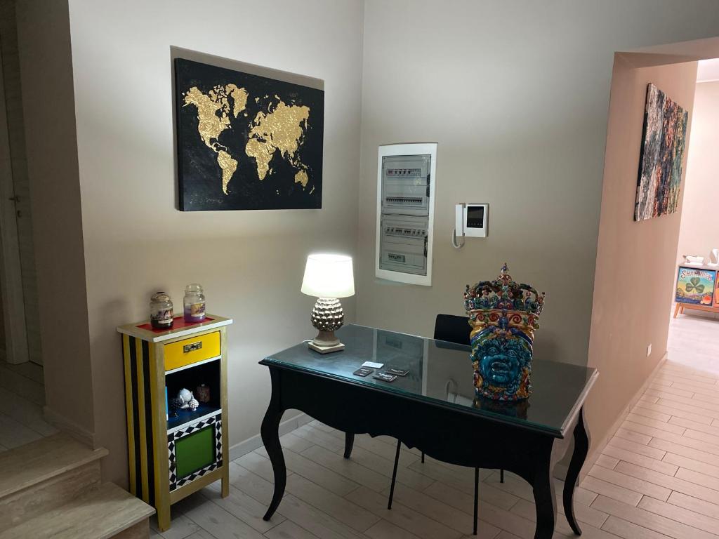 um quarto com uma secretária com um candeeiro e um mapa na parede em Palazzo Liberty em Monreale
