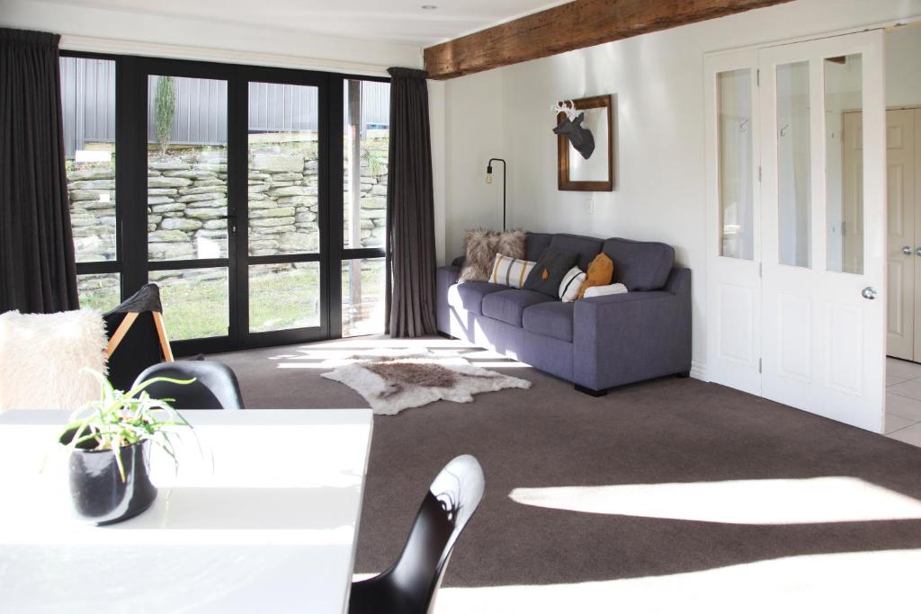 a living room with a couch and a table at Sunny Lakeside Haven in Queenstown