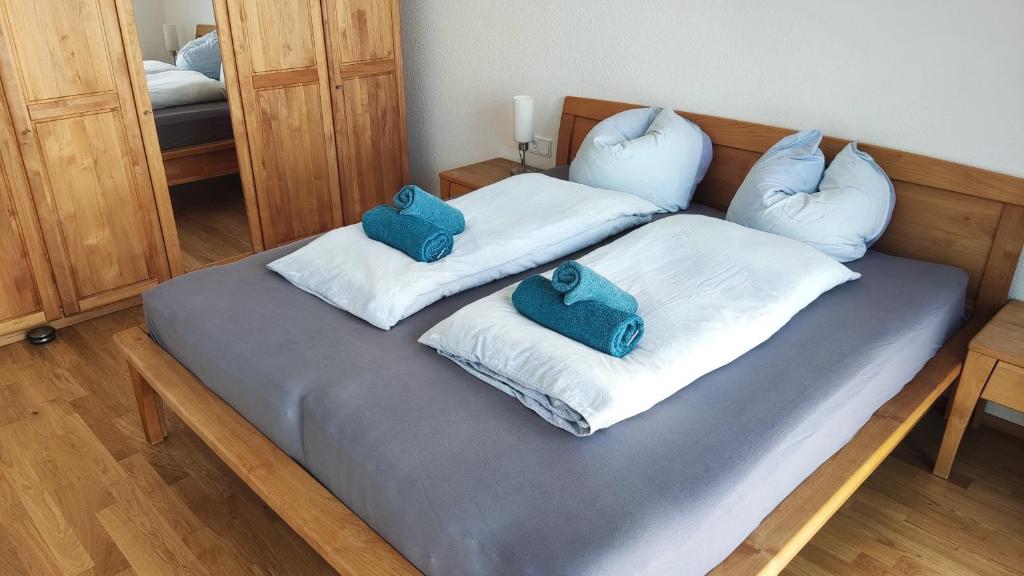 a bed with two blue pillows on top of it at Apartment "SUN" in Friedrichshafen