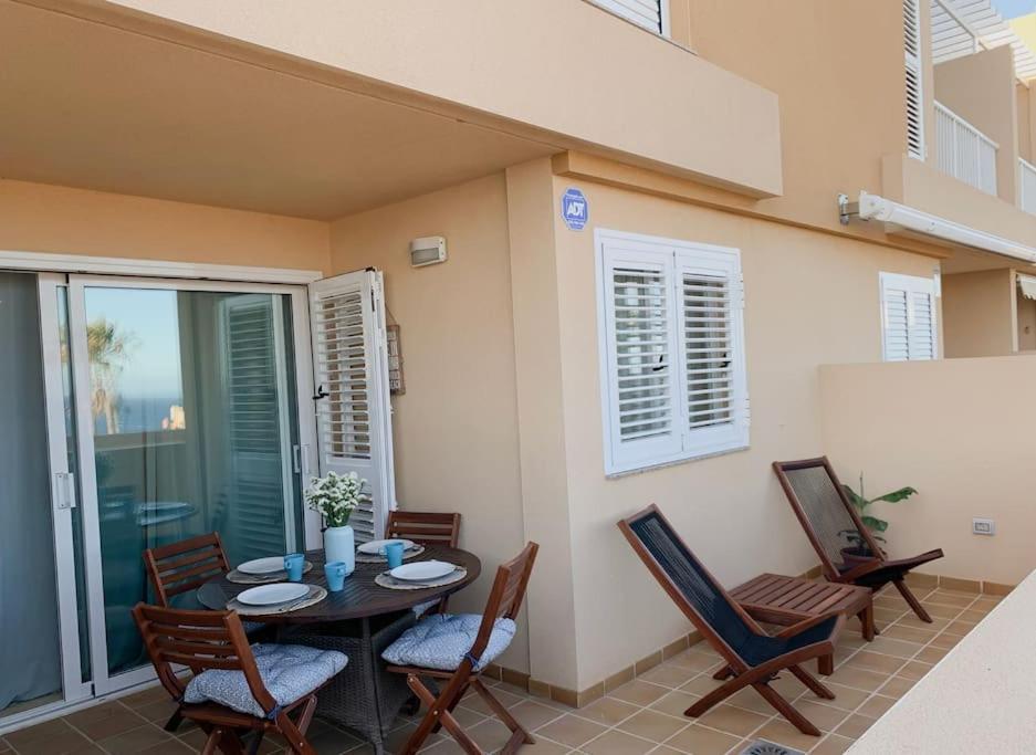 Apartamento con vistas al mar el Porís في بوريس دي أبونا: فناء مع طاولة وكراسي وشرفة
