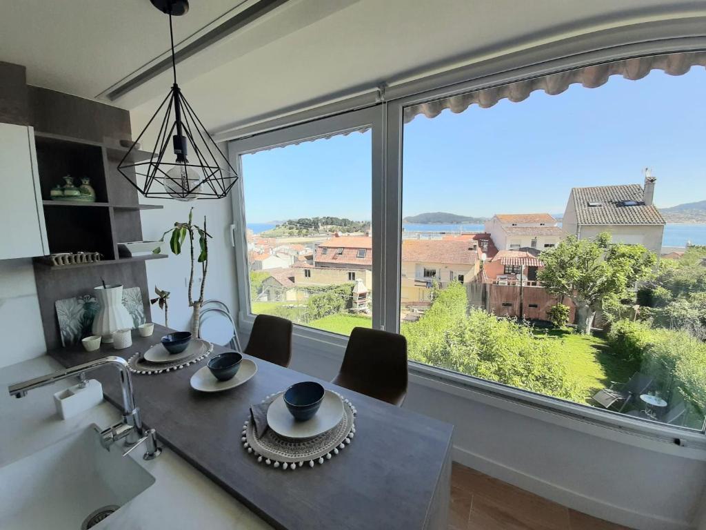 a dining room with a table and a large window at Chalet en el centro de Baiona con vistas in Baiona