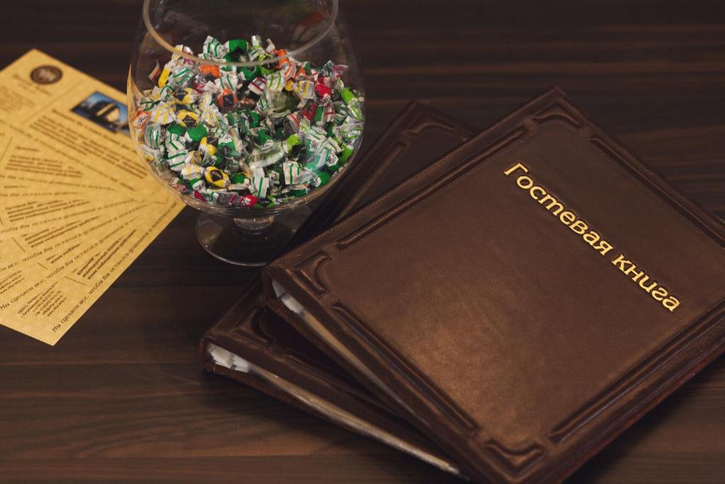 a book and a glass bowl of sprinkles on a table at Villa Aino in Petrozavodsk