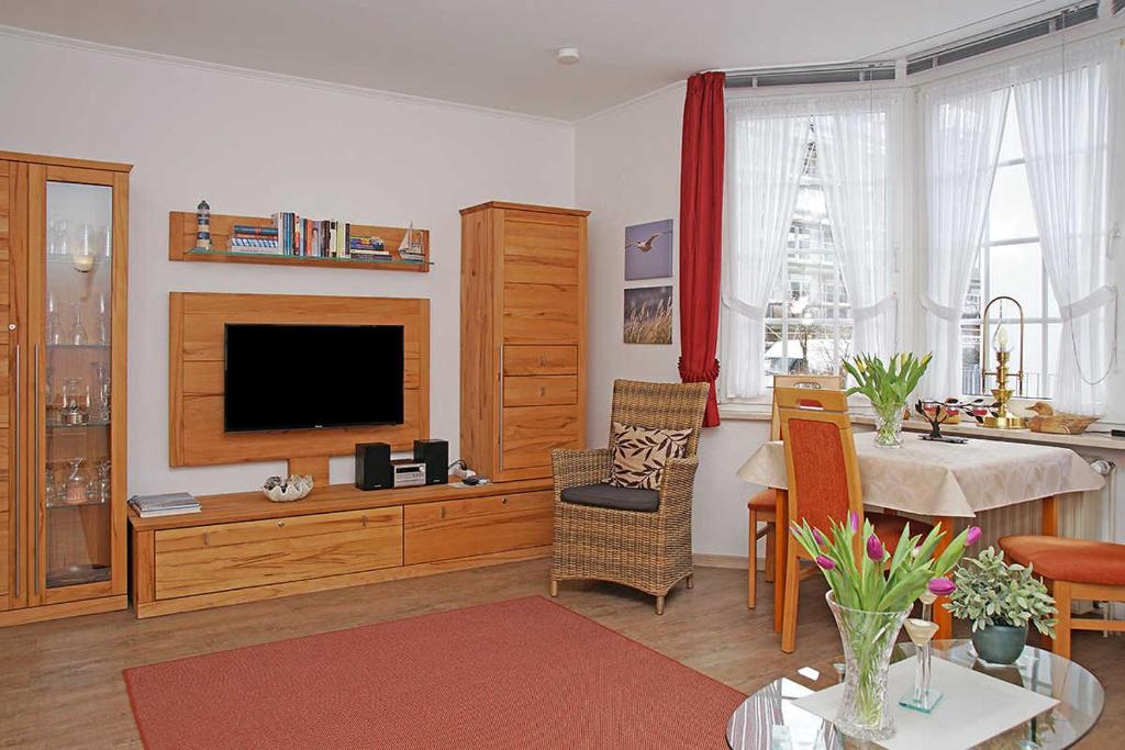 een woonkamer met een televisie en een eetkamer bij Fischerhus _ Wohnung 2 in Cuxhaven