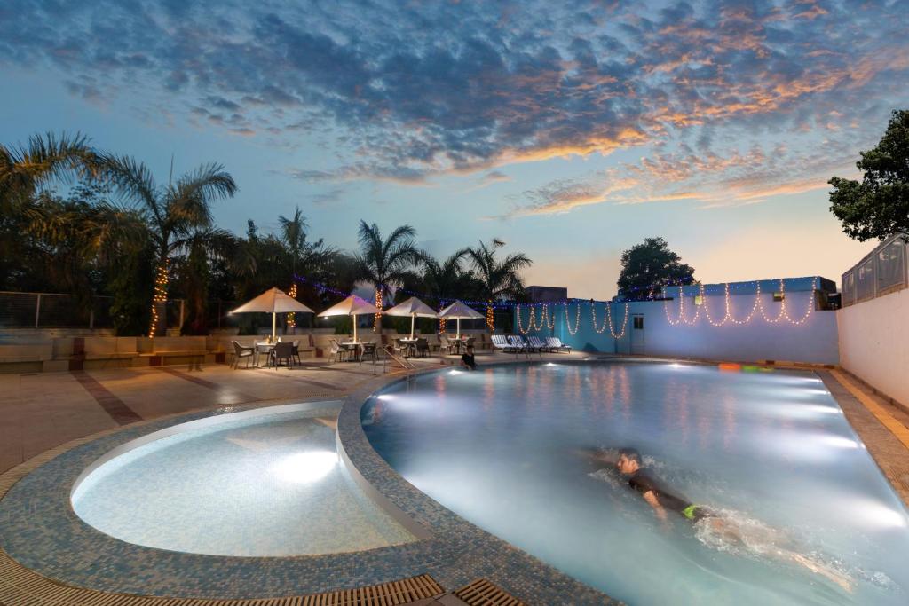 a swimming pool at a resort at night at The Competent Palace Hotel in Jhājra