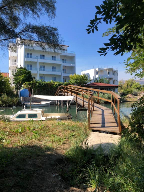 a wooden bridge over a river in front of a building at Apartments Cungu in Ulcinj