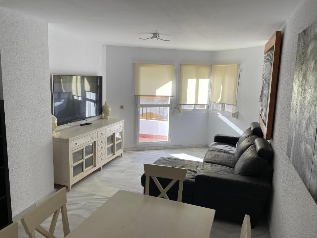 un soggiorno con divano e TV di Apartamento BudhaZahara a Zahara de los Atunes