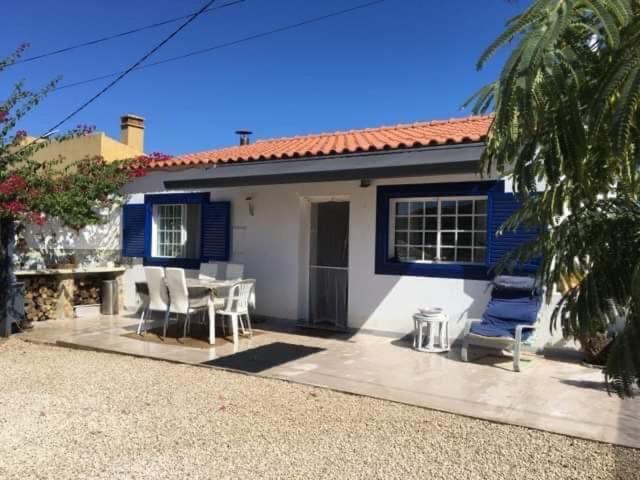Casa azul y blanca con mesa y sillas en Quinta Vale de Luz en Silves