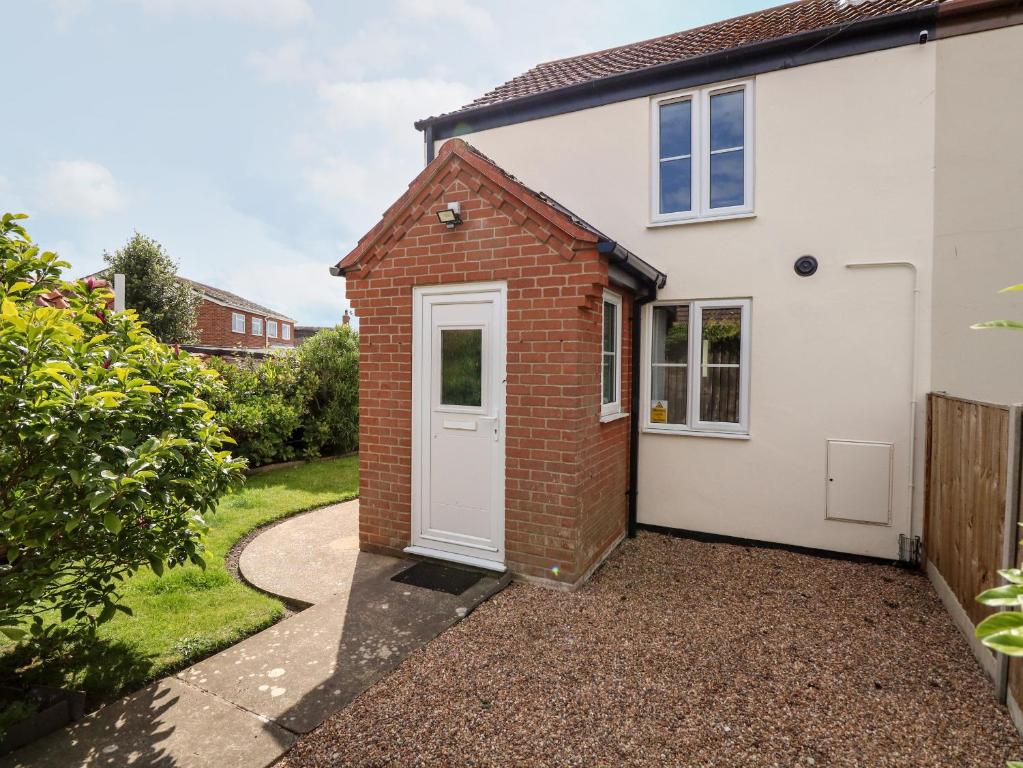 a brick and white house with a white door at 3 The Cottages in Great Yarmouth