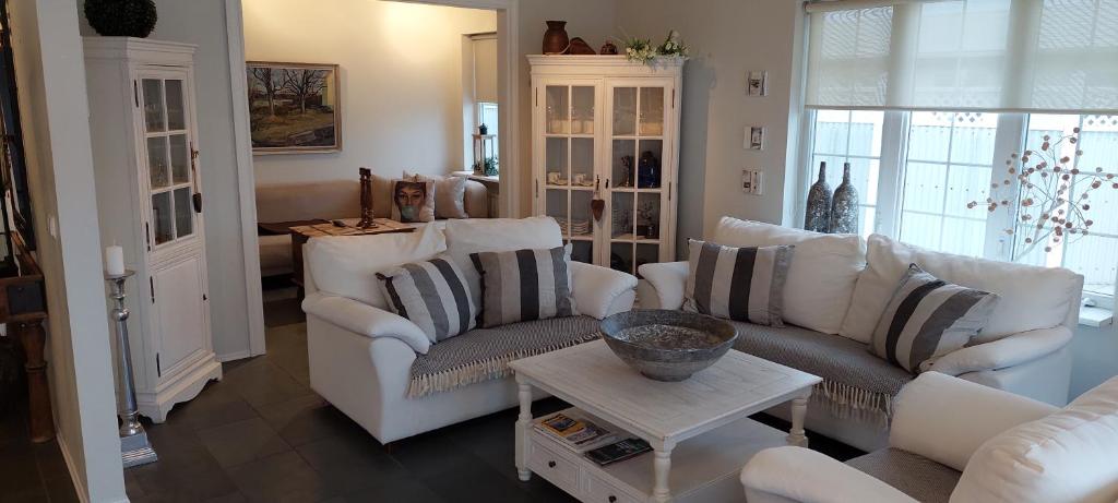 una sala de estar con sofás blancos y una mesa. en Ocean Front Villa en Vogar