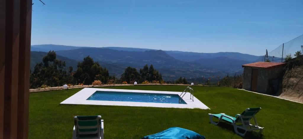 a yard with a swimming pool and two lawn chairs at Bungalow com piscina in Celorico de Basto