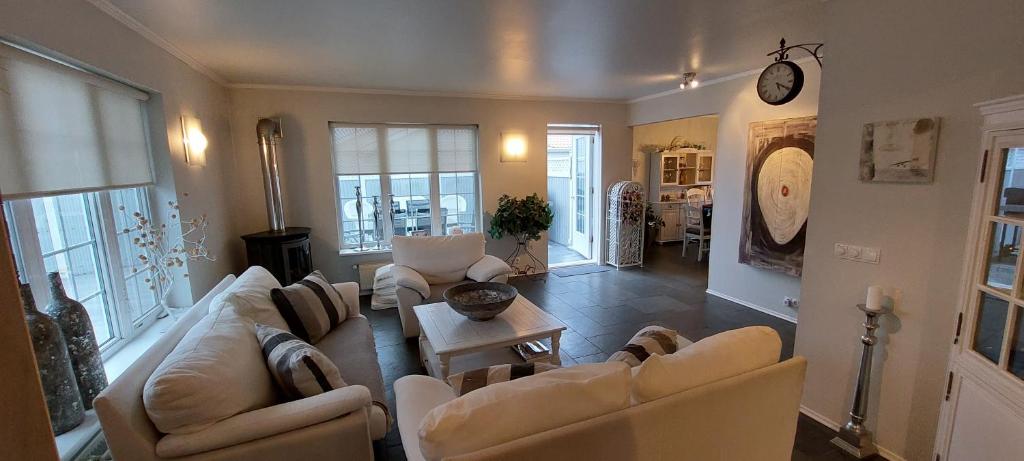 a living room with couches and a table at Ocean Front Villa in Vogar